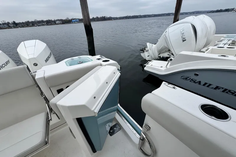 Slide: The Image of Twin Mercury outboard engines on a 2025 Sailfish 276 DC boat, docked on calm water. - 11