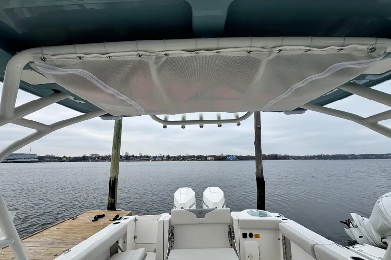 Slide: The Image of 2025 Sailfish 276 DC boat at sunset, city skyline reflection on calm water. - 14