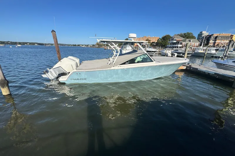 Slide: The Image of 2025 Sailfish 276 DC boat docked in a marina under clear blue skies. - 5