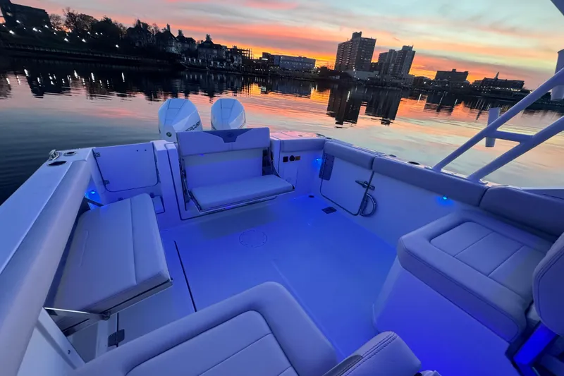Slide: The Image of 2025 Sailfish 276 DC boat interior at sunset, with city skyline reflection. - 8