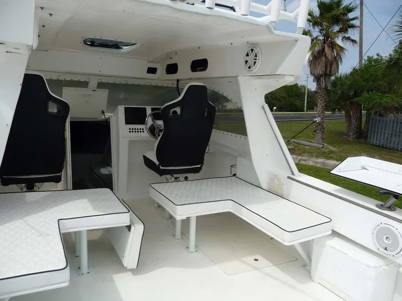 Slide: The Image of 1985 Wellcraft Scarab 34 interior with seating and steering wheel, featuring a sleek white design. - 13