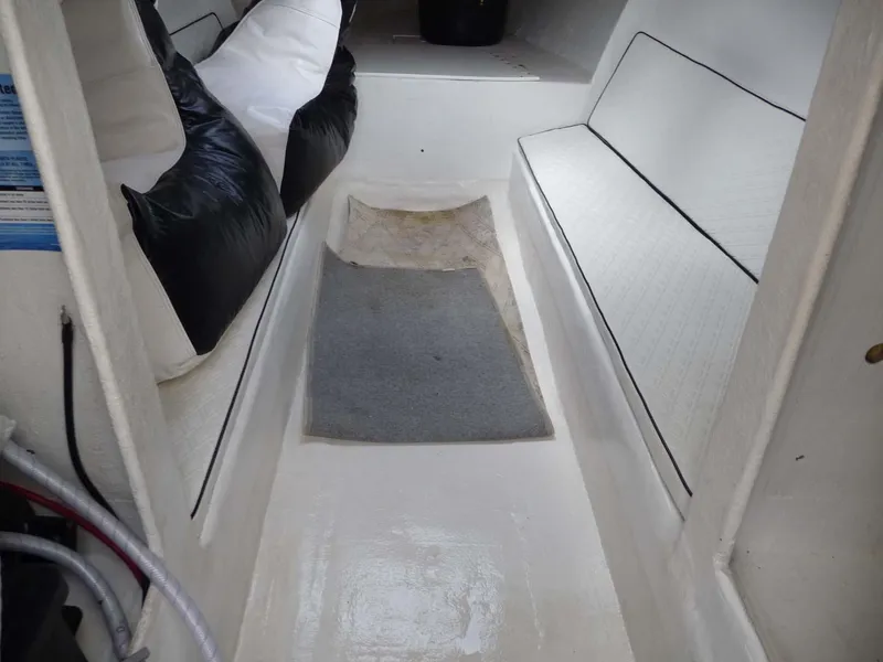Slide: The Image of Interior of 1985 Wellcraft Scarab 34 boat, featuring white seating and a gray floor mat. - 19