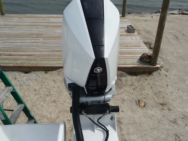Slide: The Image of 1985 Wellcraft Scarab 34 outboard motor on sandy beach near wooden deck. - 24