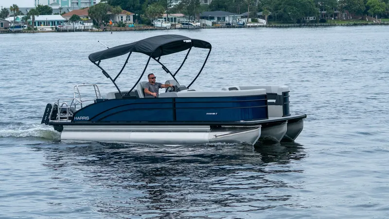 Slide: The Image of 2026 Harris Cruiser 230 pontoon boat on the water. - 2