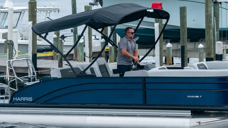 Slide: The Image of Harris Cruiser 230 pontoon boat 2026 at dock with driver. - 5