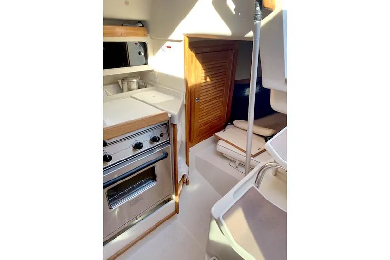 Slide: The Image of Interior of 2006 Catalina 28 sailboat featuring compact kitchen and cozy seating area. - 3