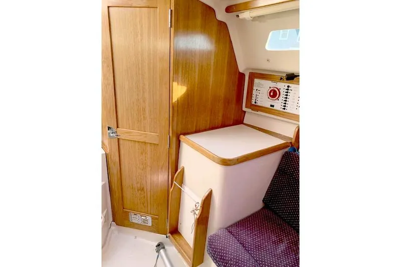 Slide: The Image of Interior of 2006 Catalina 28 sailboat with wooden cabinetry and control panel. - 4