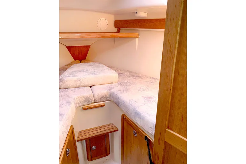 Slide: The Image of Interior cabin of a 2006 Catalina 28 sailboat with cozy bedding and wooden accents. - 7