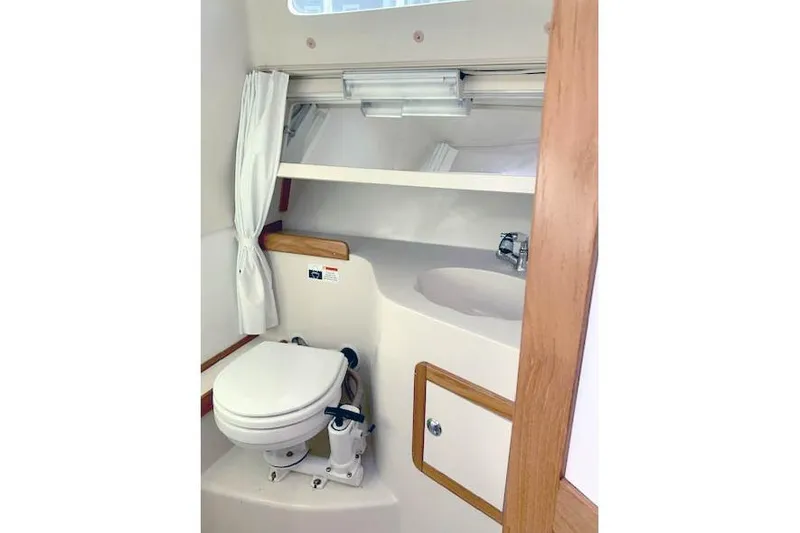 Slide: The Image of Compact bathroom in a 2006 Catalina 28 sailboat, featuring a toilet and sink. - 9