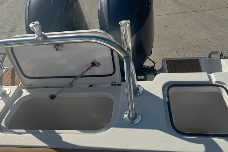 Slide: The Image of 2022 Sea Hunt Gamefish 25 boat with open storage compartments and dual engines. - 12
