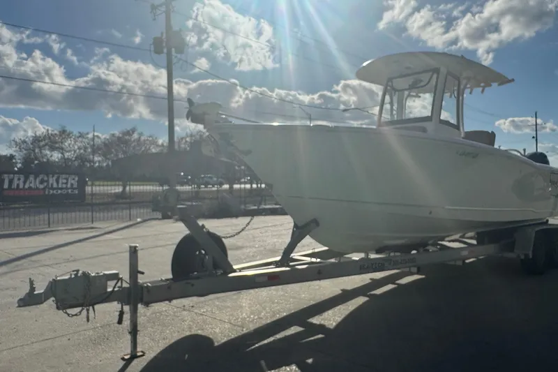Slide: The Image of 2022 Sea Hunt Gamefish 25 boat on trailer under sunny sky. - 2