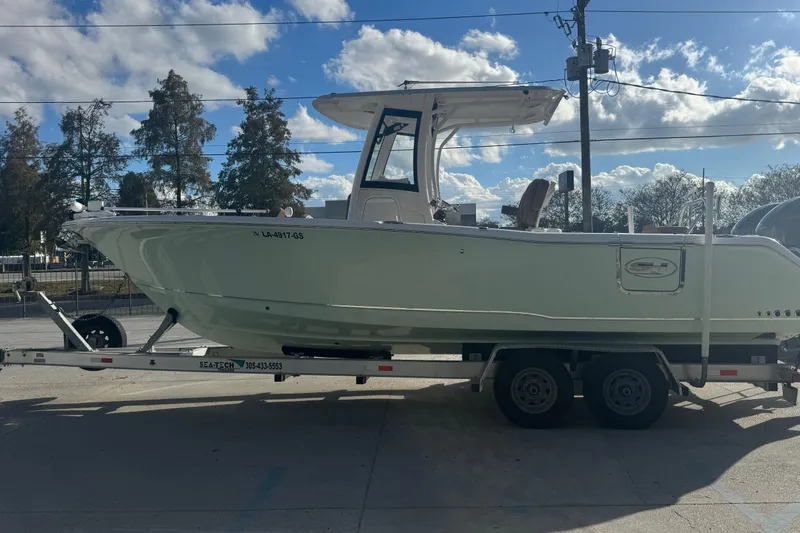 Slide: The Image of 2022 Sea Hunt Gamefish 25 boat on trailer under a clear blue sky. - 3