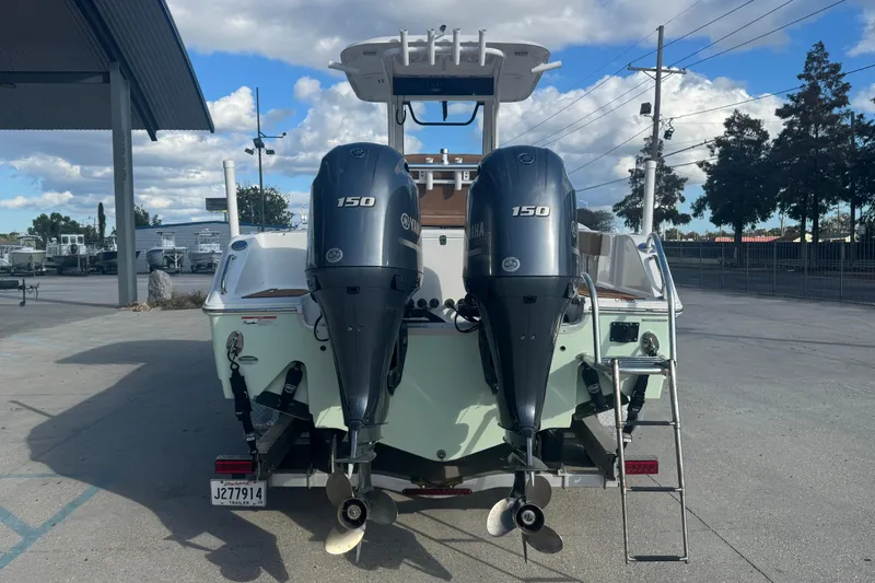 Slide: The Image of 2022 Sea Hunt Gamefish 25 boat with dual Yamaha 150 engines, parked outdoors. - 4