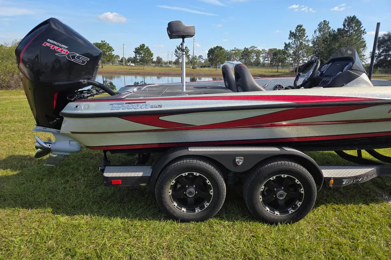 Slide: The Image of 2021 Triton 20 TrX boat with Mercury Pro XS engine on grassy field. - 1