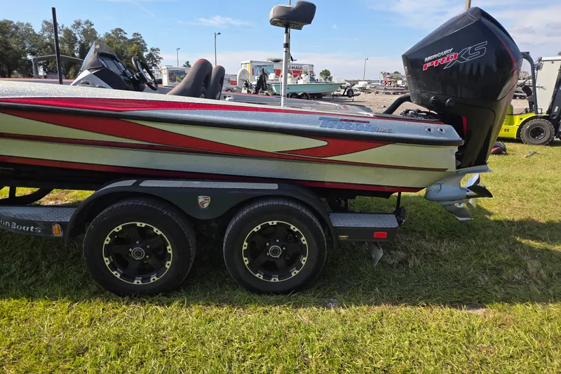 Slide: The Image of 2021 Triton 20 TrX boat on trailer, parked on grass under clear sky. - 6