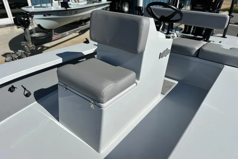 Slide: The Image of 2025 East Cape VHP boat interior with gray cushioned seating and steering console. - 16