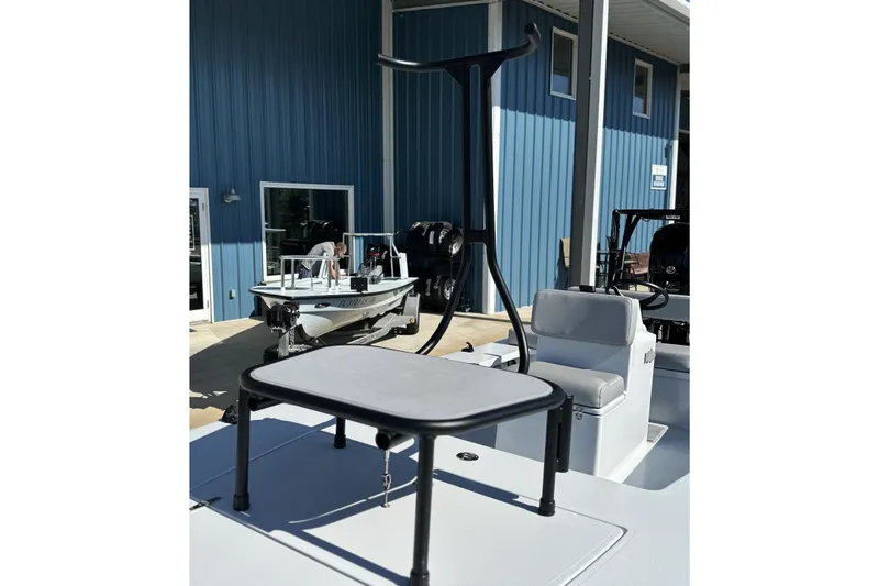 Slide: The Image of 2025 East Cape VHP boat with seating and table, displayed outdoors near a blue building. - 19