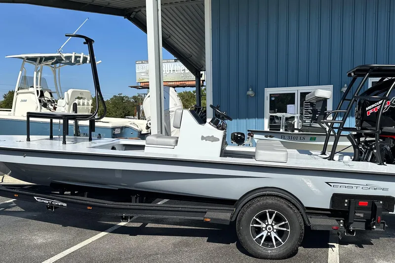 Slide: The Image of 2025 East Cape VHP boat on trailer, parked outside a blue building. - 3