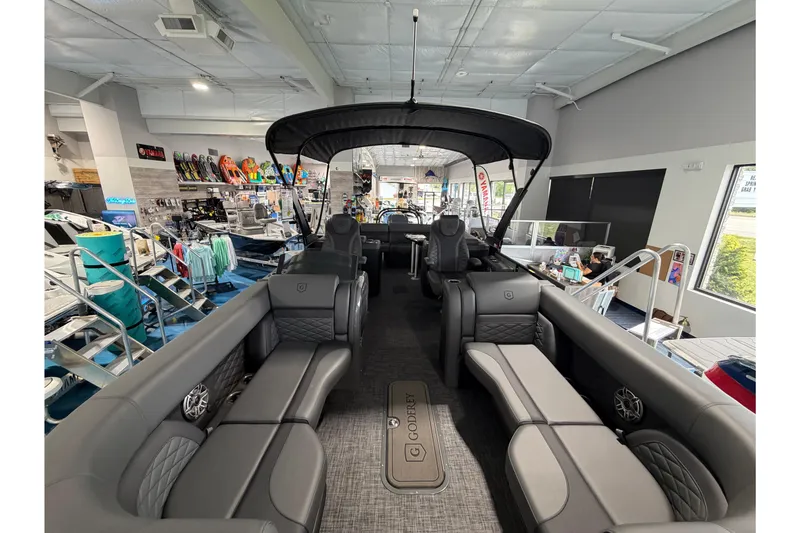 Slide: The Image of 2026 Godfrey Monaco 235ULC pontoon boat interior with luxurious seating in a showroom. - 5