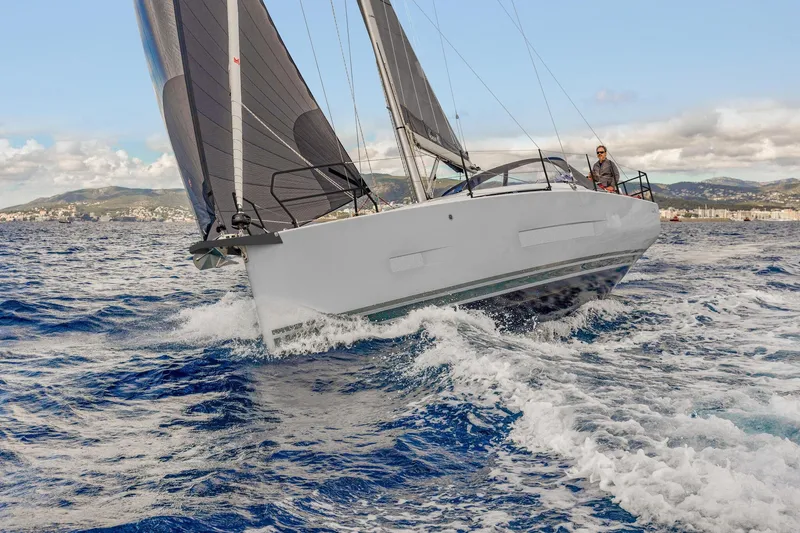 Slide: The Image of Sailing yacht Hanse 360 ST 2026 navigating through waves, with scenic coastal backdrop. - 6