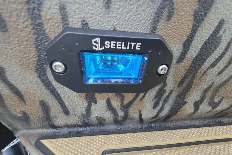 Slide: The Image of 2026 Xpress X18DB boat on trailer, camo design, parked on gravel. - 10