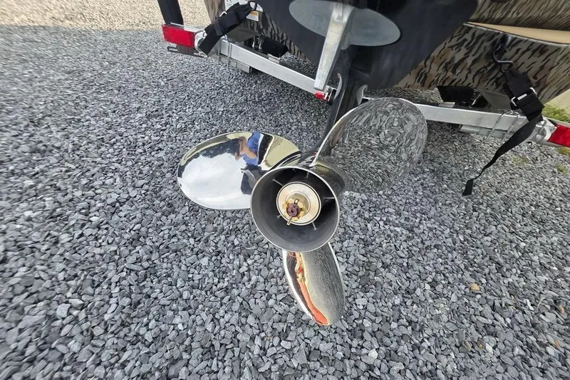 Slide: The Image of 2026 Xpress X18DB boat with camouflage design on a gravel surface. - 11