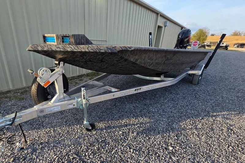 Slide: The Image of 2026 Xpress X18DB boat on trailer, parked outside a building. - 2