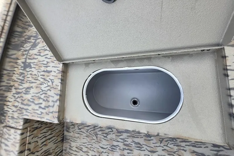 Slide: The Image of 2026 Xpress X18DB boat with camouflage design, parked on gravel near red buildings. - 29