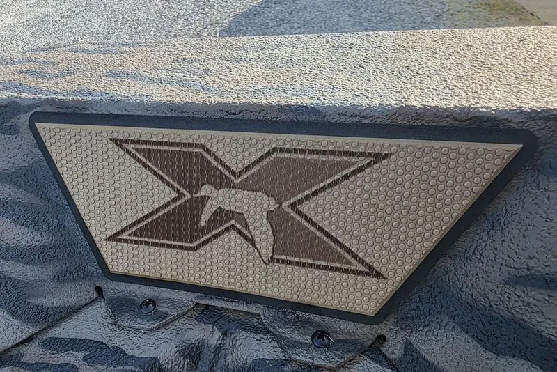 Slide: The Image of 2026 Xpress X18DB boat on trailer, parked on gravel near a building. - 5