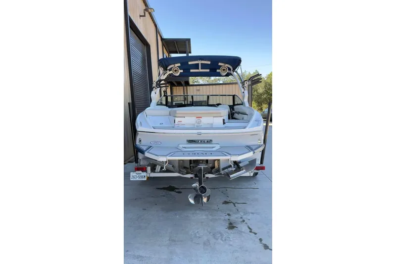 Slide: The Image of 2020 Cobalt CS23 Surf boat parked in a garage, rear view. - 9