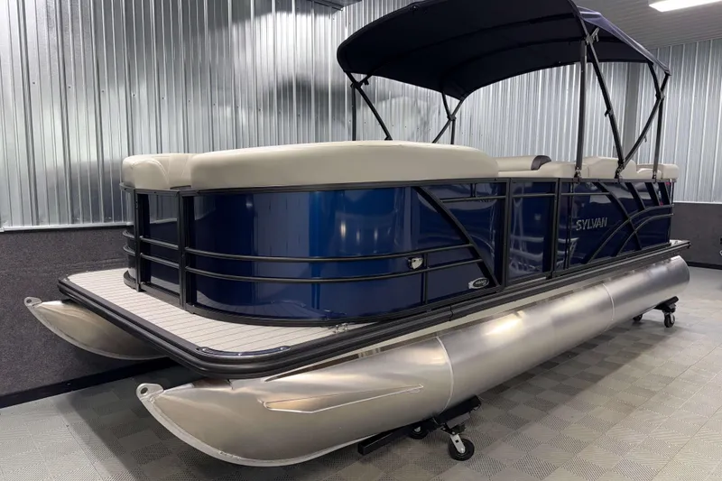 Slide: The Image of 2026 Sylvan Mirage 820 Cruise pontoon boat with blue exterior and canopy in showroom. - 16