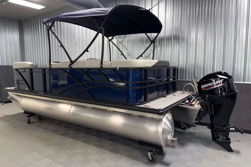Slide: The Image of 2026 Sylvan Mirage 820 Cruise pontoon boat with Mercury outboard motor in a showroom. - 21