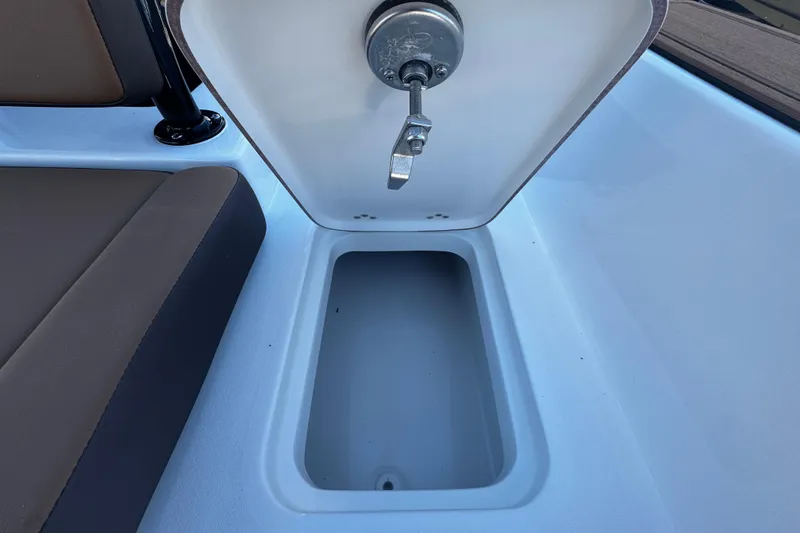 Slide: The Image of Open storage compartment on 2026 Sea Pro 245FLX Sandbar boat, featuring secure latch. - 17