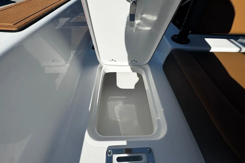 Slide: The Image of Storage compartment on 2026 Sea Pro 245FLX Sandbar boat, open lid, white interior. - 18