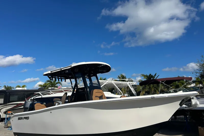 Slide: The Image of 2026 Sea Pro 245FLX Sandbar boat under clear blue sky with palm trees. - 2
