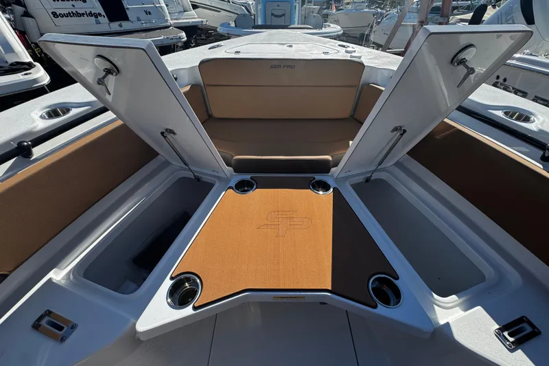 Slide: The Image of 2026 Sea Pro 245FLX Sandbar boat interior with open storage compartments and cup holders. - 43