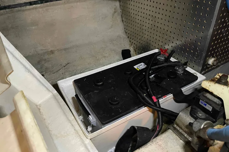 Slide: The Image of Battery compartment in a 2002 President Trawler boat, featuring wiring and secure installation. - 100