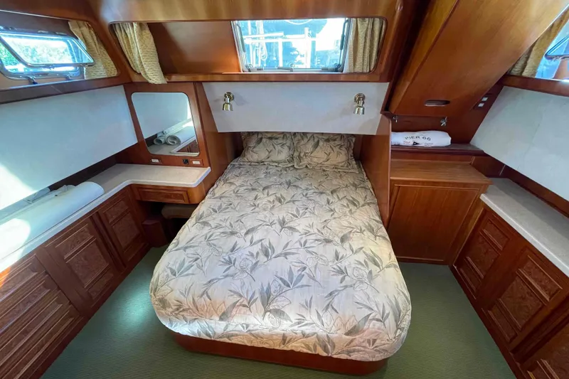 Slide: The Image of Luxurious 2002 President Trawler cabin with elegant wood finish and cozy bedding. - 11