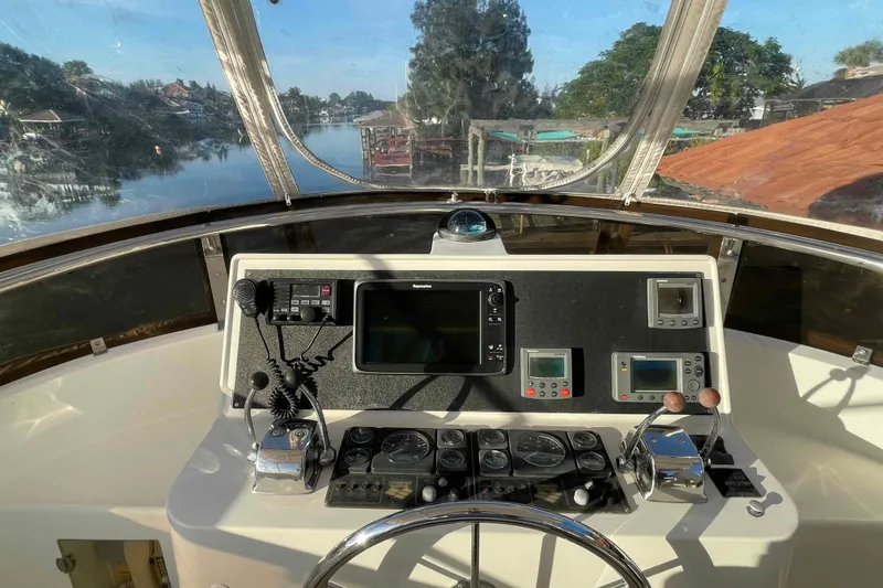 Slide: The Image of Helm of 2002 President Trawler with navigation instruments and scenic waterway view. - 16