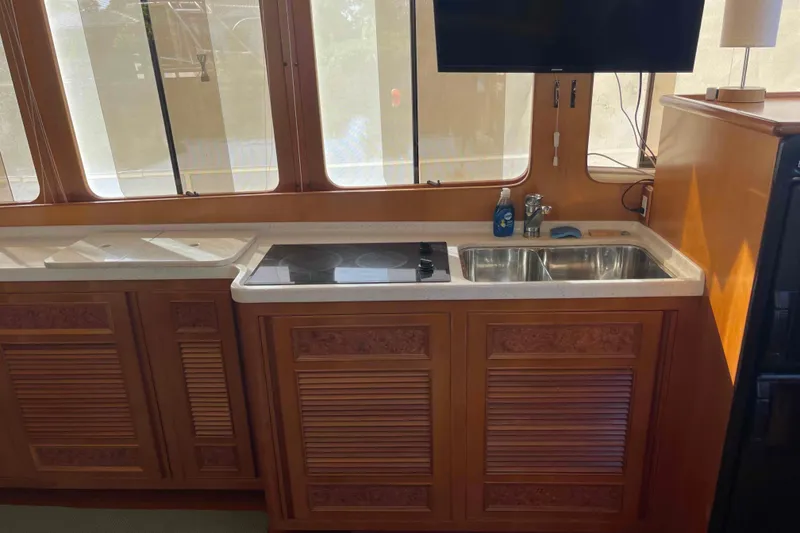 Slide: The Image of Kitchen area in a 2002 President Trawler with stove, sink, and wooden cabinetry. - 48