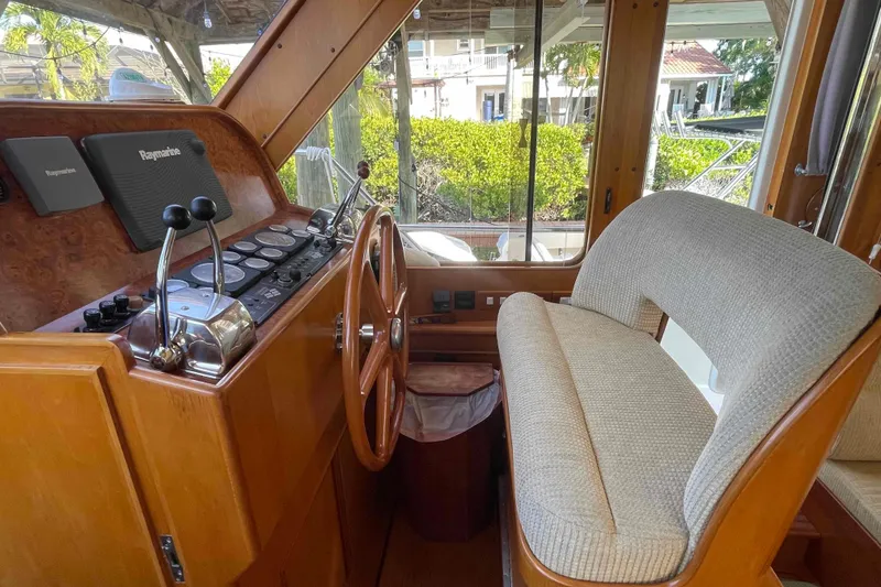 Slide: The Image of 2002 President Trawler helm with wooden steering wheel and Raymarine navigation system. - 6