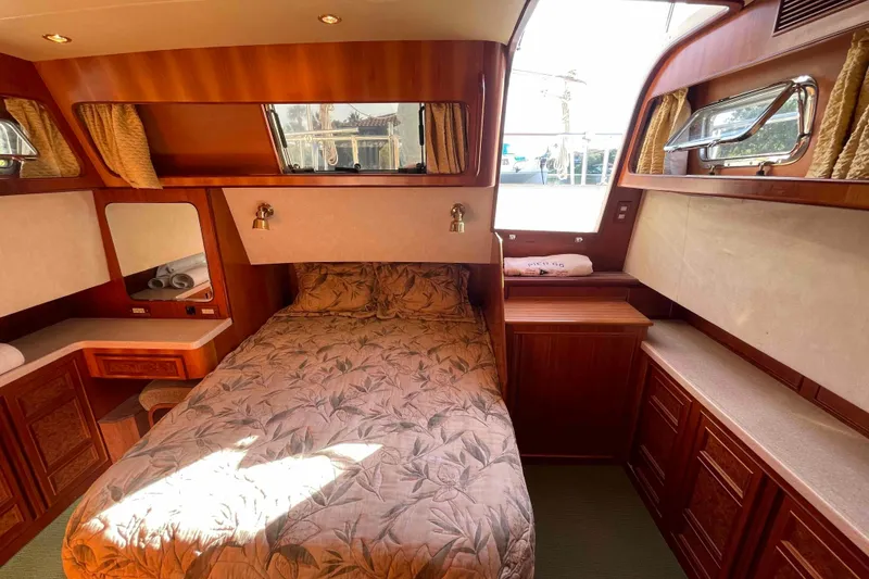 Slide: The Image of Luxurious 2002 President Trawler cabin with elegant wood finish and cozy bedding. - 63