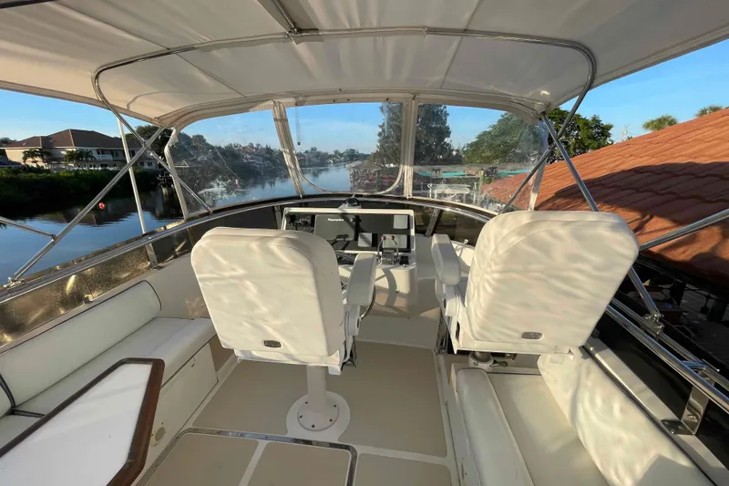 Slide: The Image of 2002 President Trawler helm with white seating, overlooking serene waterfront view. - 70