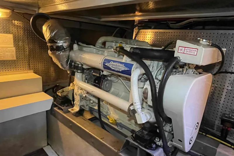 Slide: The Image of Engine room of a 2002 President Trawler, featuring a diesel engine and mechanical components. - 83