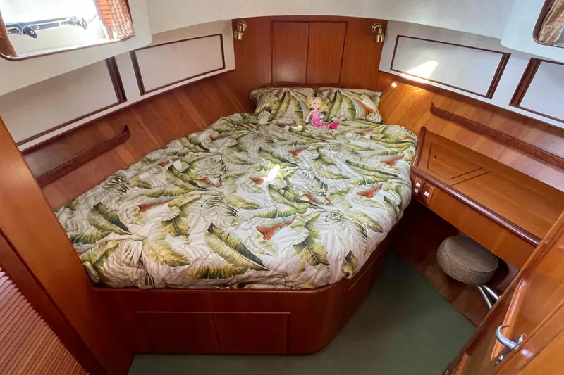 Slide: The Image of Cozy cabin interior of 2002 President Trawler with tropical bedding and wooden furnishings. - 9
