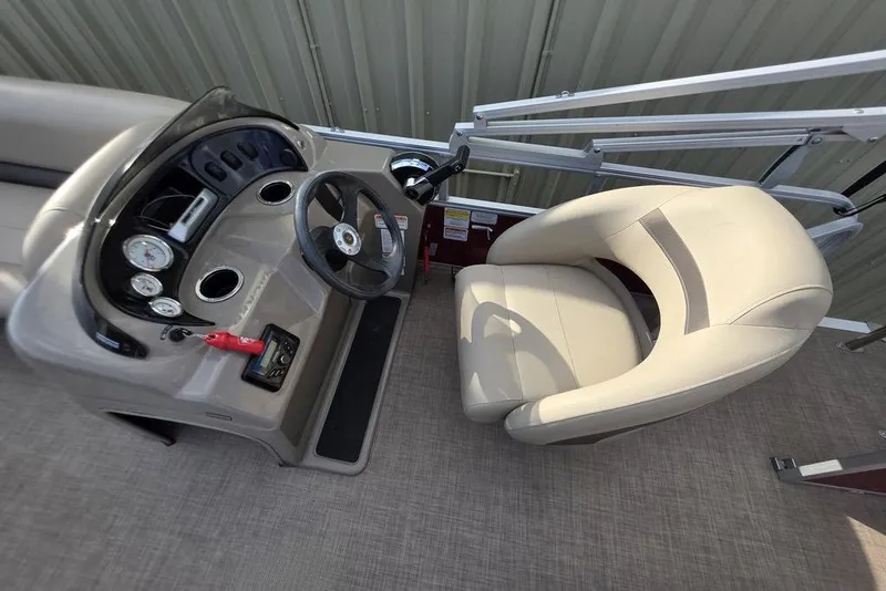 Slide: The Image of 2023 Sun Tracker Party Barge 18 DLX helm with beige captain's chair and control panel. - 10