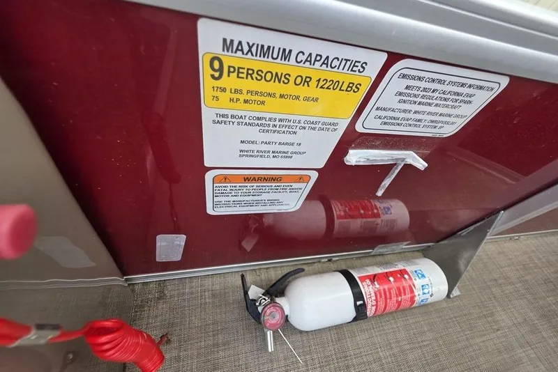 Slide: The Image of 2023 Sun Tracker Party Barge 18 DLX capacity label and fire extinguisher on deck. - 17