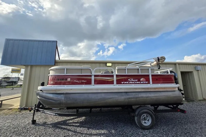 Slide: The Image of 2023 Sun Tracker Party Barge 18 DLX pontoon boat on trailer, parked outdoors. - 3
