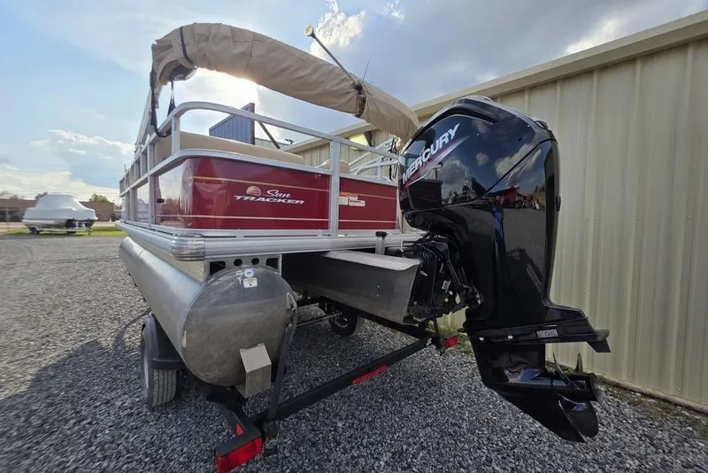 Slide: The Image of 2023 Sun Tracker Party Barge 18 DLX with Mercury outboard motor, parked on gravel. - 7