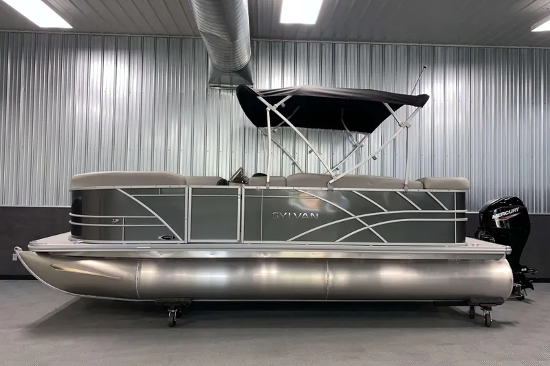 Slide: The Image of 2026 Sylvan Mirage 820 Cruise pontoon boat in a showroom, featuring sleek design and Mercury outboard motor. - 15